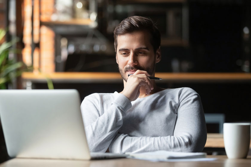 young man overcoming indecision while doing research