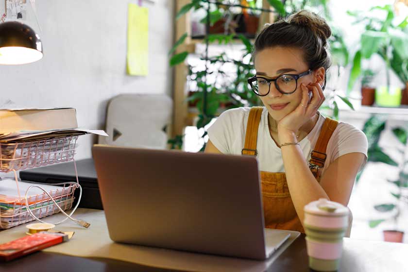Girl looking at computer screen smiling making the right decision