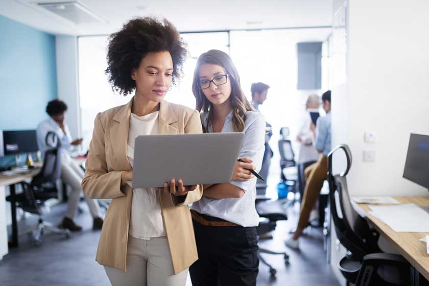 CEO and bookkeeper looking at the 2025 fall executive outlook report on their computer