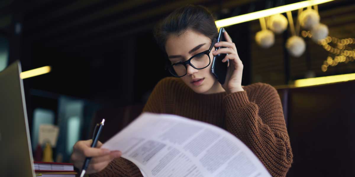 Bookkeeper talking on the phone while checking reports