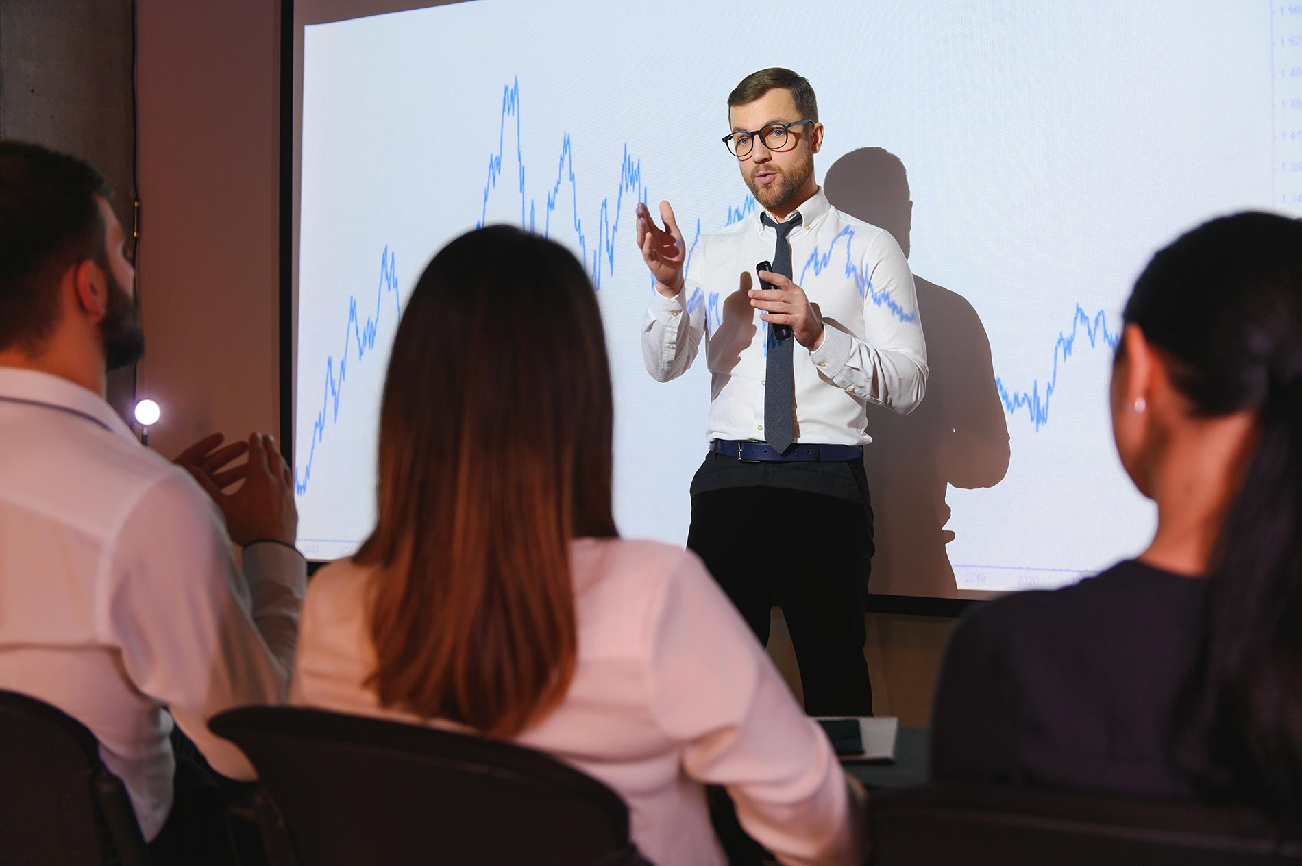 business executive giving a presentation on financial narrative in front of an audience