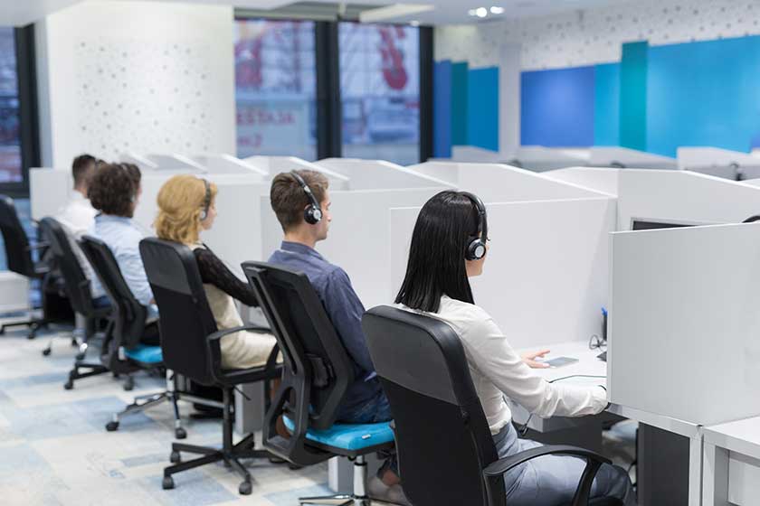 outsourced bookkeepers sitting in cubicles next to each other
