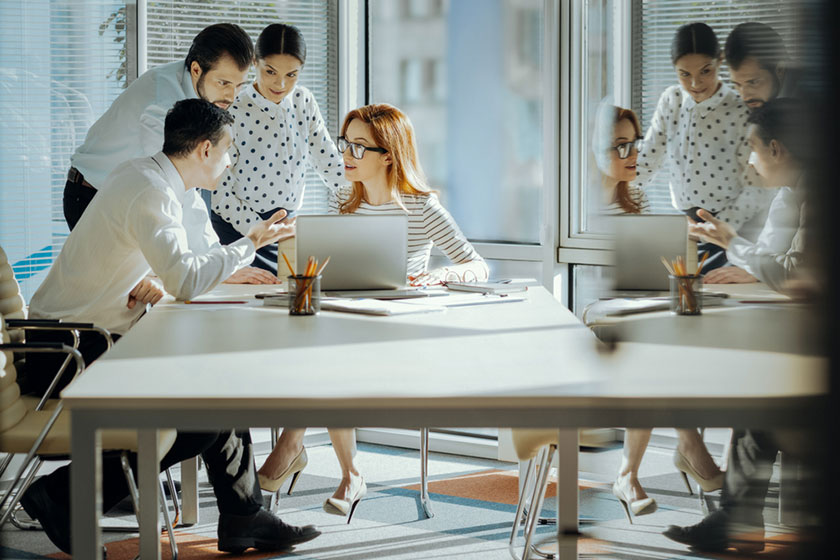 manager giving feedback to multiple employees of distinct cultural backgrounds